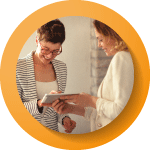 two lady looking at a piece of paper together